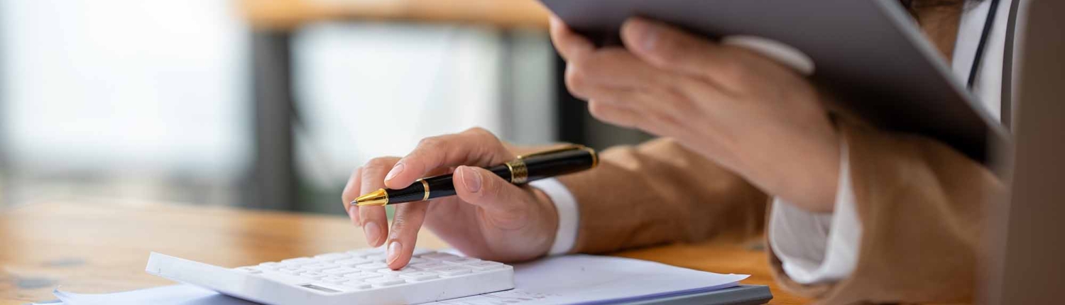 Close up of businesswomen or accountant using calculator calculate while working analytic business report on the workplace
