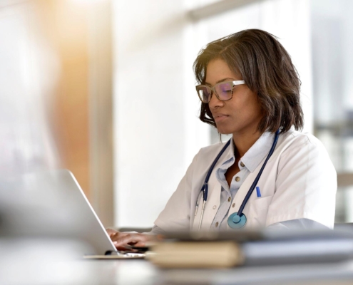 Medical professional working at laptop