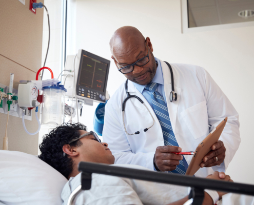 Patient talking to doctor while lying on hospital bed