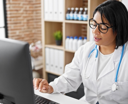 Medical professional looking at files on computer