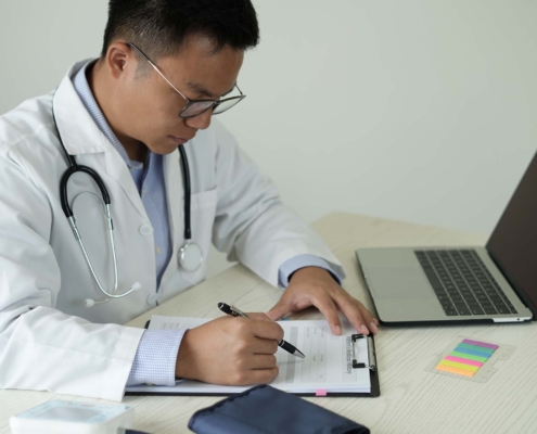 Medical professional at desk looking at files